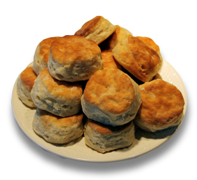 Golden-brown buttermilk biscuits arranged on a cream plate, ideal for wholesale foodservice suppliers and food distributors.