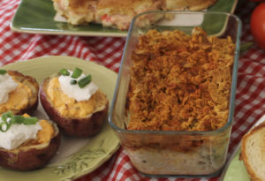 Professional food service presentation featuring chicken salad-filled baked potatoes topped with sour cream and chives, ideal for catering and wholesale food distribution.